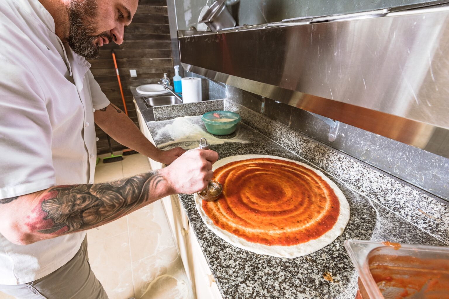 Bearded man chef preparing pizza at local business