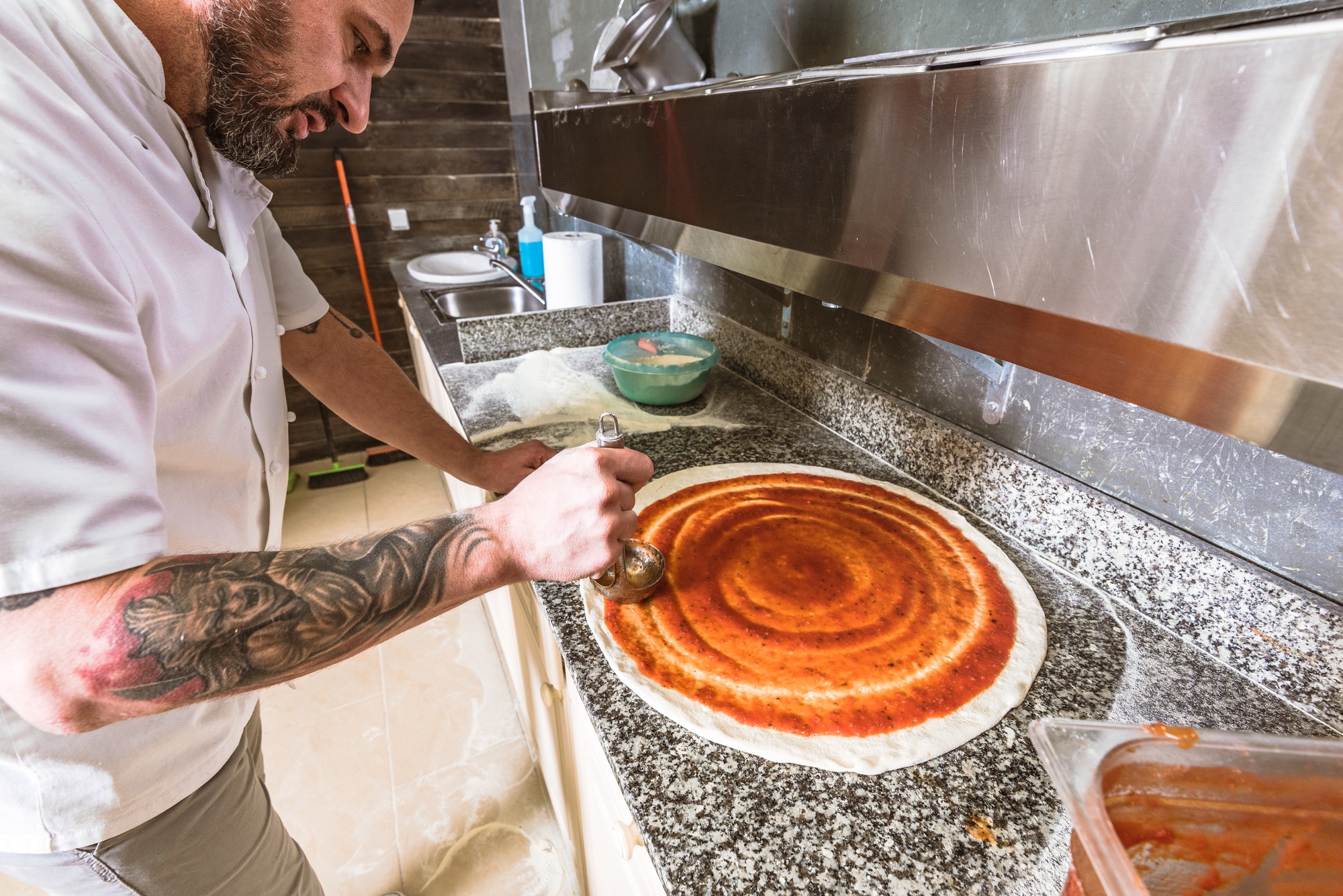 Bearded man chef preparing pizza at local business